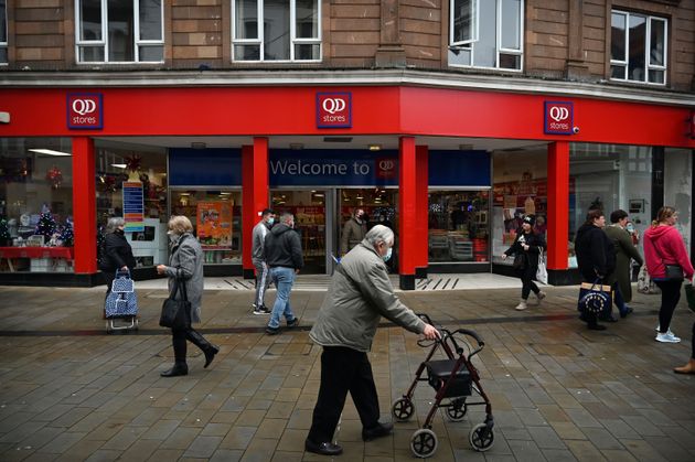 People walk in a shopping high street in Wrexham, North Wales on November 9.