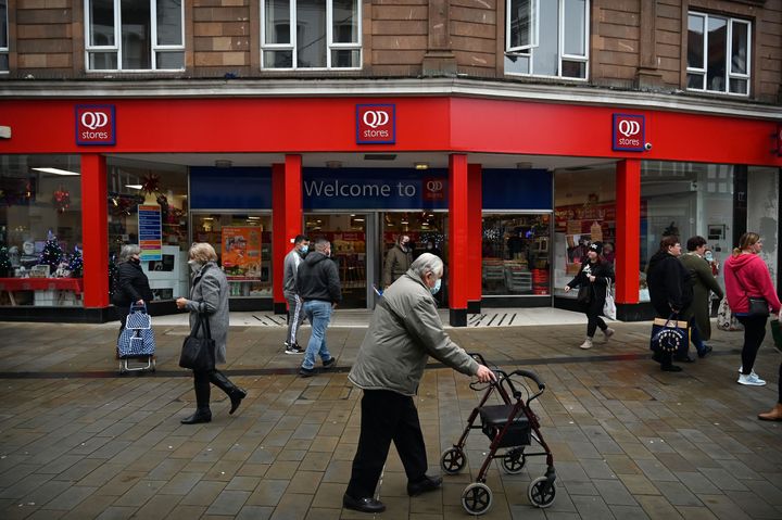 People walk in a shopping high street in Wrexham, North Wales on November 9.