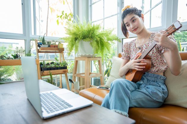 A woman learns a musical instrument online