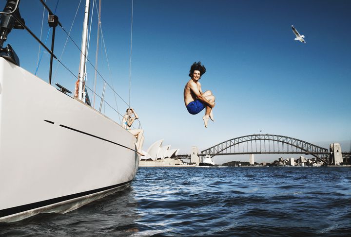 Australia, Sydney, young man jumping from boat in to harbour