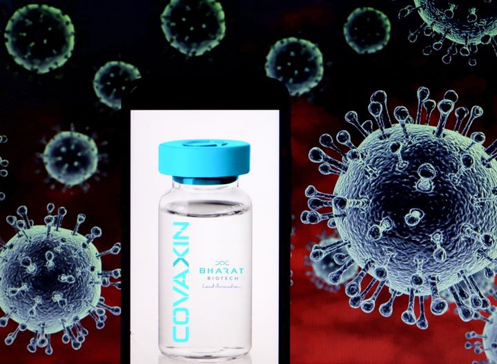 In this Photo illustration a logo of Covaxin seen displayed on a smartphone with a COVID-19 coronavirus image in the background. 