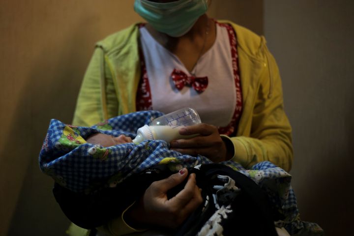 A 17-year-old mother gives a bottle to her 2-week-old baby, whom she says was born as a result of a rape in Sumatra, Indonesia, Sunday, Sept. 9, 2018. She started working on a plantation as a young child to help her family survive, never going to school or learning how to read or write. One day she said her boss took her alone to a quiet part of the estate. After the attack, while still half-naked, she said the man held a blade to her throat. "He threatened to kill me with an ax. ... He threatened to kill my whole family." Then, she said, he stood up, spit on her and walked away. 
