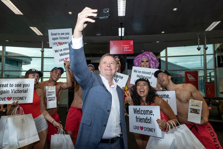 Labour leader Anthony Albanese poses for a photo with models waiting to greet passengers from Melbourne arriving at the Sydney Domestic terminal on November 23, 2020 in Sydney, Australia. 