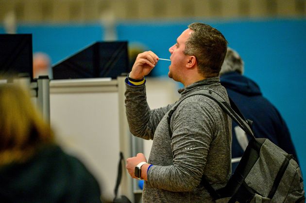 Members of the public complete a test swab during a lateral flow Covid test at Rhydycar leisure centre in Merthyr Tydfil