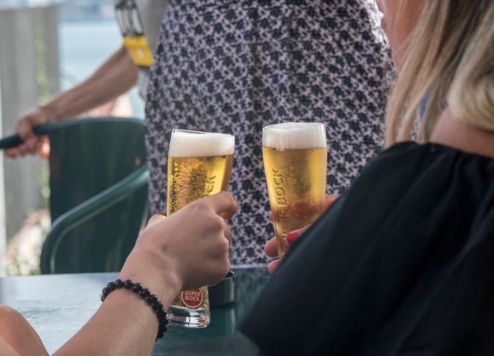Dos personas toman cerveza en una terraza.