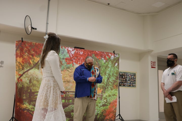 The author and her husband at their wedding in the prison visit room with their chaplain Brian Henry.