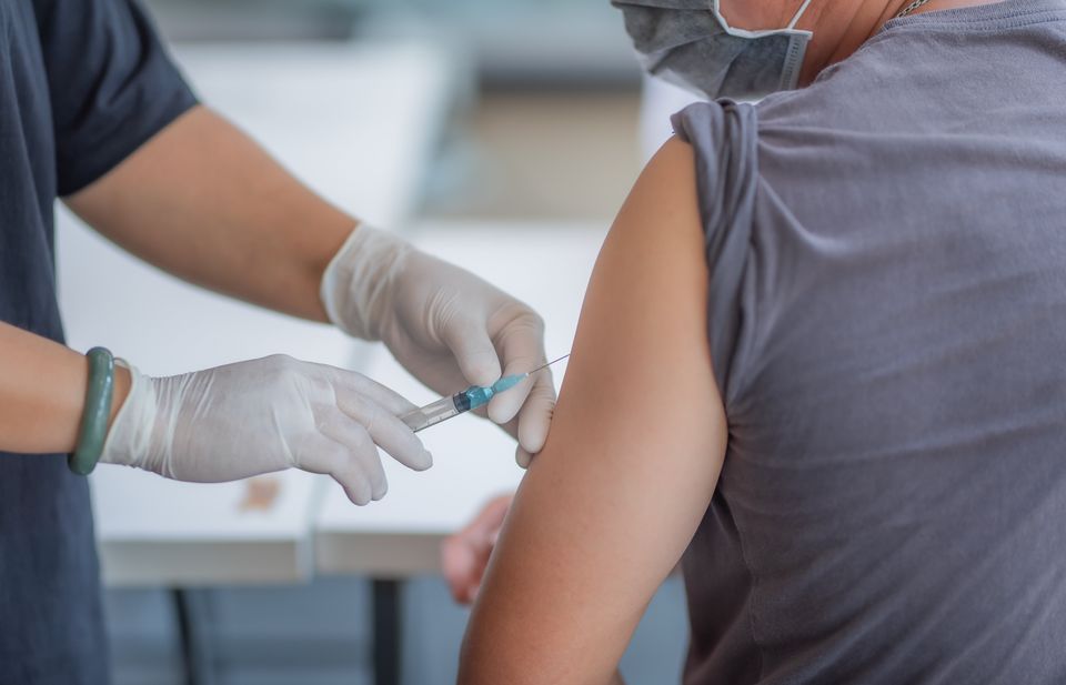 A doctor injects a patient with a vaccine. 