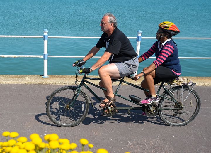 Tandem bike riders cycle along the seafront on June 24 in Weymouth, United Kingdom. Here, the tandem bike frame is clearly lo