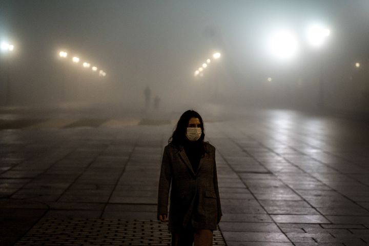Una mujer pasea entre la niebla en Madrid.