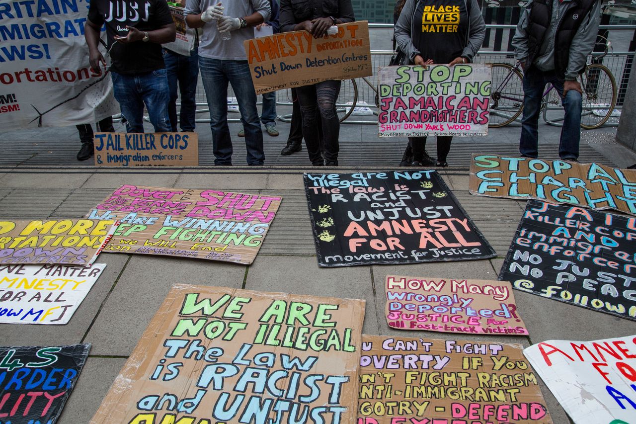 Demonstrators display their protest placards outside the Home Office during a demonstration calling for rights for immigrants in the UK on July 4, 2020. 