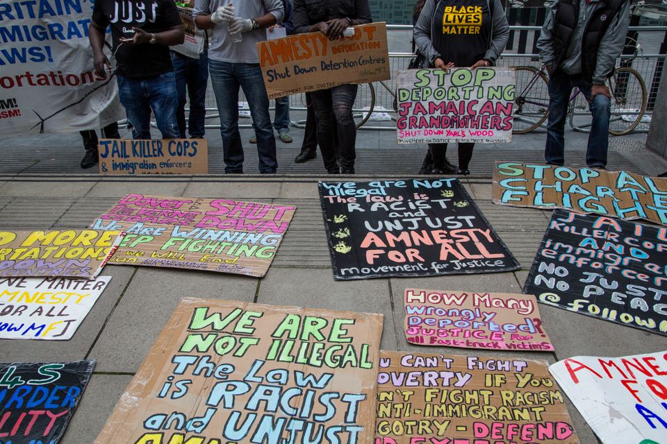 Demonstrators display their protest placards outside the Home Office during a  demonstration calling for rights for immigrants in the UK on July 4, 2020. 