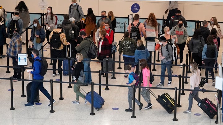 Air travelers line up to go through a security checkpoint at Salt Lake City International Airport Wednesday, Nov. 25, 2020, i