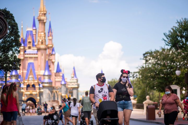 Guests wear required face masks due to the Covid-19 pandemic on Main Street, U.S.A. in front of Cinderella Castle at Walt Disney World Resort's Magic Kingdom on Wednesday, August 12, 2020, in Lake Buena Vista, Fla. (Photo by Charles Sykes/Invision/AP)