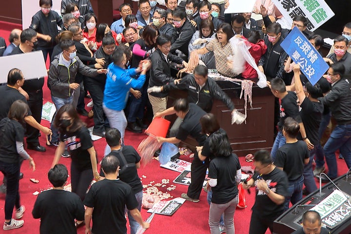 Taiwan's lawmakers got into a fist fight and threw pig guts at each other Friday over a soon-to-be enacted policy that would
