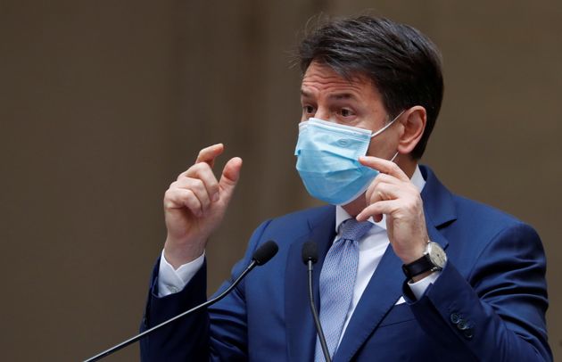 Italian Prime Minister Giuseppe Conte, wearing a protective mask, gestures while speaking during a news ...