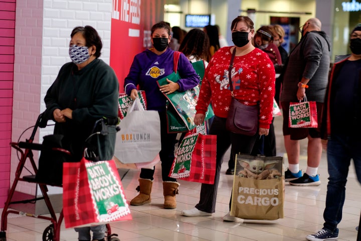 Black Friday shoppers wearing face masks wait in line to enter a store at the Glendale Galleria in Glendale, Calif., Friday,