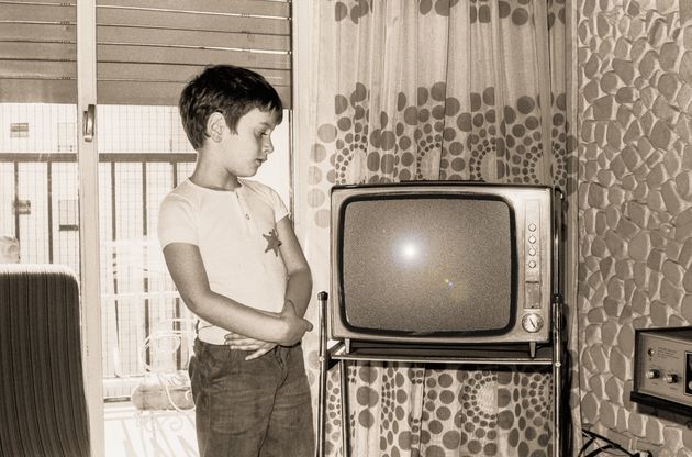 Vintage  black and white photo boy looking at an old tv
