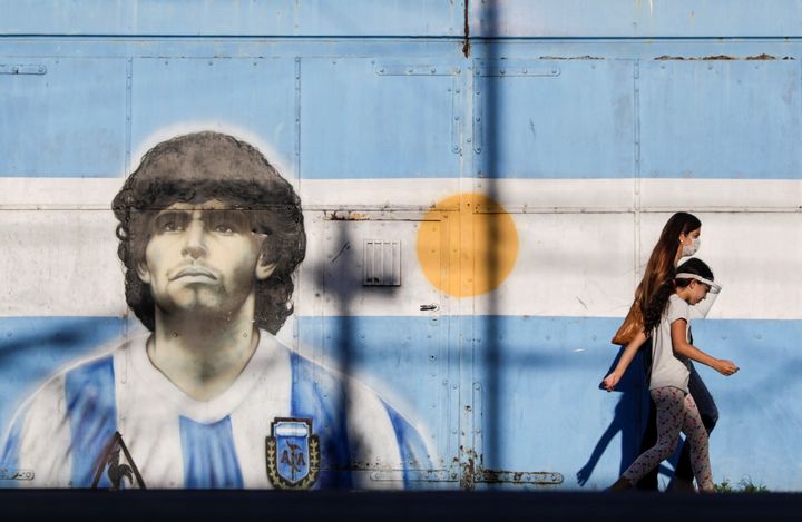 FILE PHOTO: People walk past a graffiti of soccer legend Diego Armando Maradona in Buenos Aires, Argentina, November 27, 2020. REUTERS/Ricardo Moraes