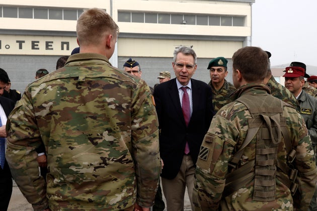 U.S. Ambassador Geoffrey Pyatt to Greece, center, speaks with U.S. soldiers at a military base in Stefanovikio, central Greece on Wednesday, Feb. 19, 2020. Army aviation forces from Greece and the United States are taking part in a live-fire exercise with attack helicopters, marking deepening defense ties between the two countries. (AP Photo/Yorgos Karahalis)