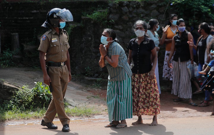 A family member of an inmate pleads to a police officer as she seeks information on the condition of her relative outside the Mahara prison complex in Mahara, outskirts of Colombo, Sri Lanka, Monday, Nov. 30, 2020. (AP Photo/Eranga Jayawardena)