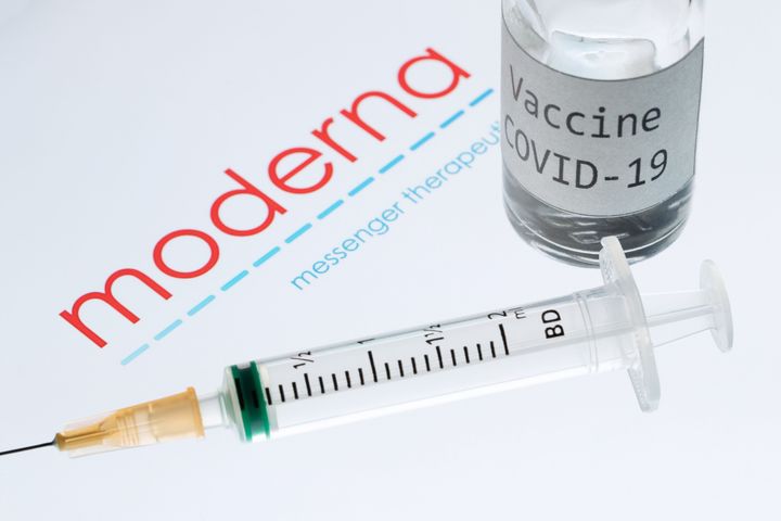 (FILES) This file photo taken on November 18, 2020 shows a syringe and a bottle reading "Vaccine Covid-19" next to the Moderna biotech company logo.