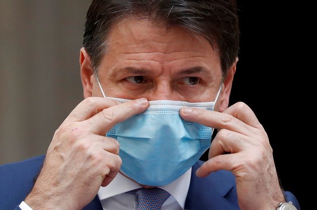 Italian Prime Minister Giuseppe Conte adjusts a protective mask while speaking during a press conference ...