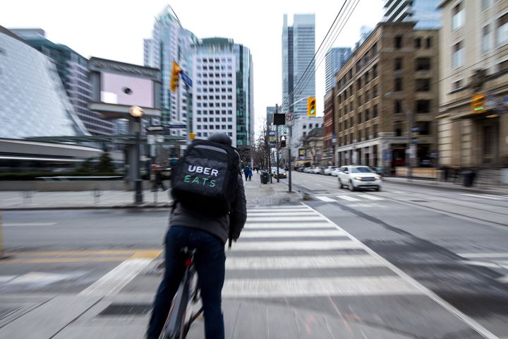 An Uber Eats food courrier on his bicycle in Toronto.