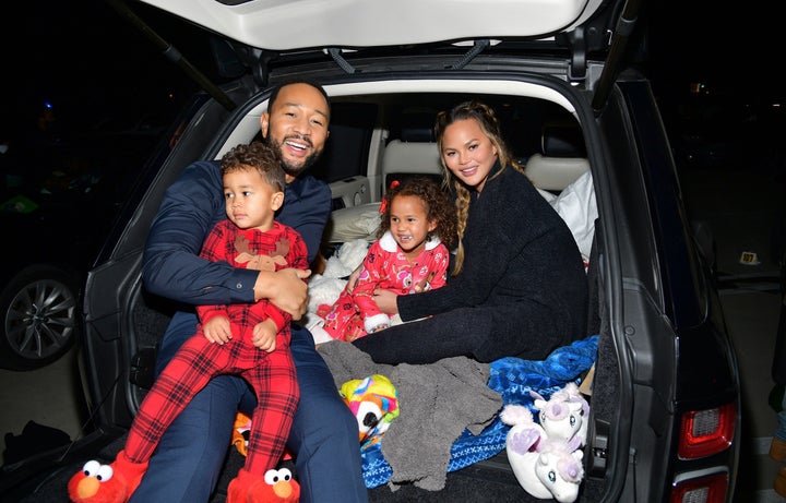 John Legend and Chrissy Teigen are pictured with Miles and Luna at Netflix's "Jingle Jangle: A Christmas Journey" drive-in premiere on Nov. 13 in Los Angeles.