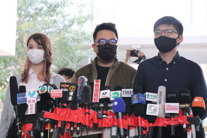 23日、香港の裁判所で記者団の取材に応じる（右から）黄之鋒、林朗彦、周庭の3氏 
