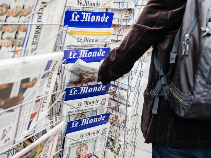 Un hombre compra el periódico 'Le Monde'.