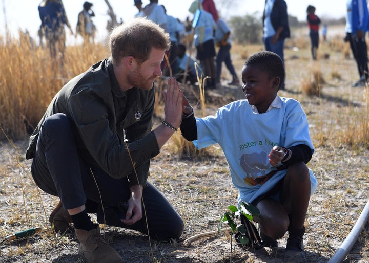 Prince Harry helps young students plant trees at the Chobe Tree Reserve in Northern Botswana on Sept. 26, 2019.