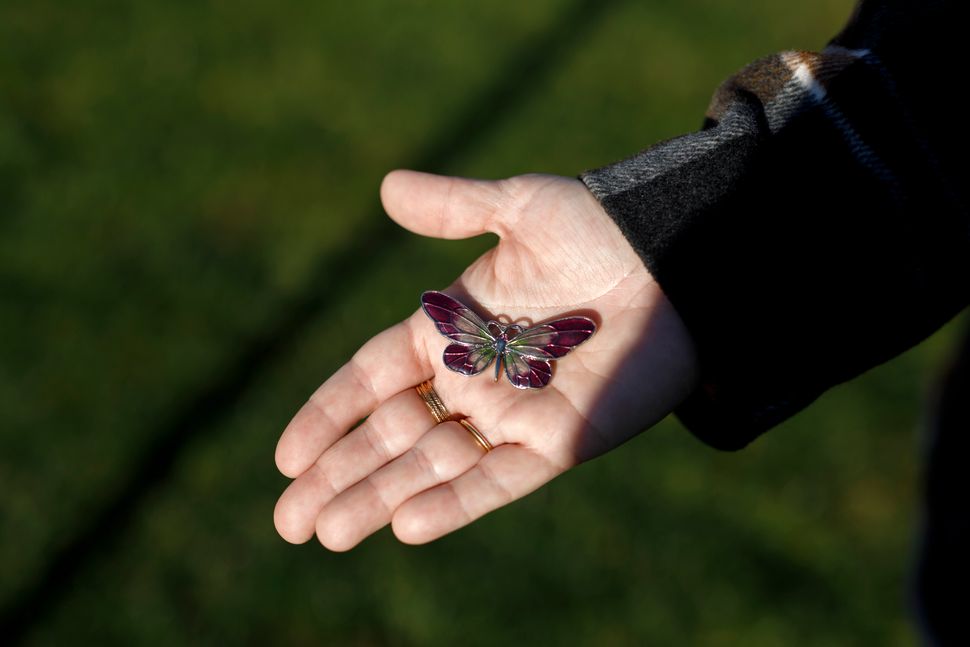 Kara Ferreira holds a butterfly brooch like the one buried with her mother Elise Arthur, whom she lost to COVID-19 as the first wave ripped through long-term care homes in Ontario. 