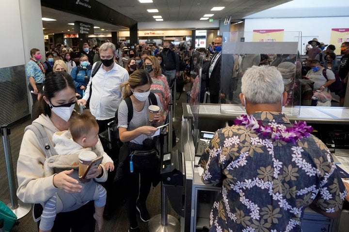 United Airlines passengers walk through the gate to board an Oct. 15 flight to Hawaii at San Francisco International Airport.