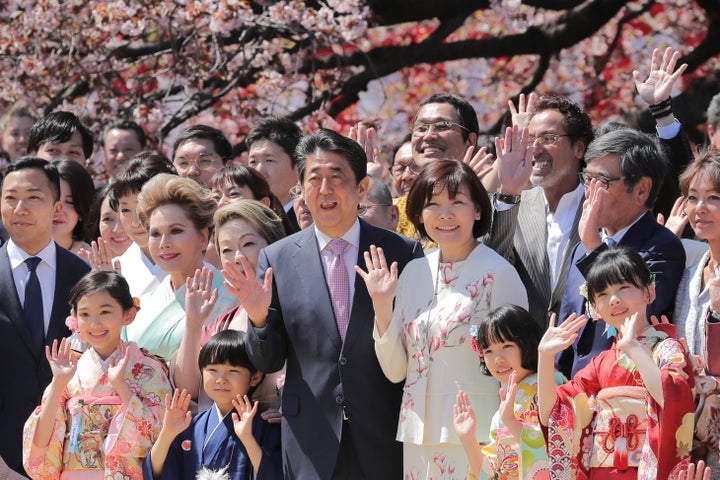 「桜を見る会」で招待客と記念撮影する安倍晋三前首相（中央）＝2019年4月、東京・新宿御苑 