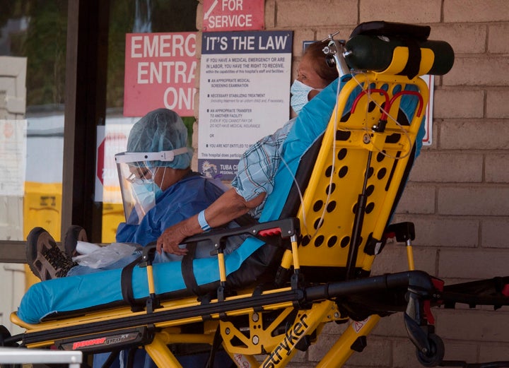 A patient is taken from an ambulance into a hospital in the Navajo Nation town of Tuba City during a 57-hour curfew, imposed to try to stop the spread of the COVID-19 virus, on May 24, 2020.