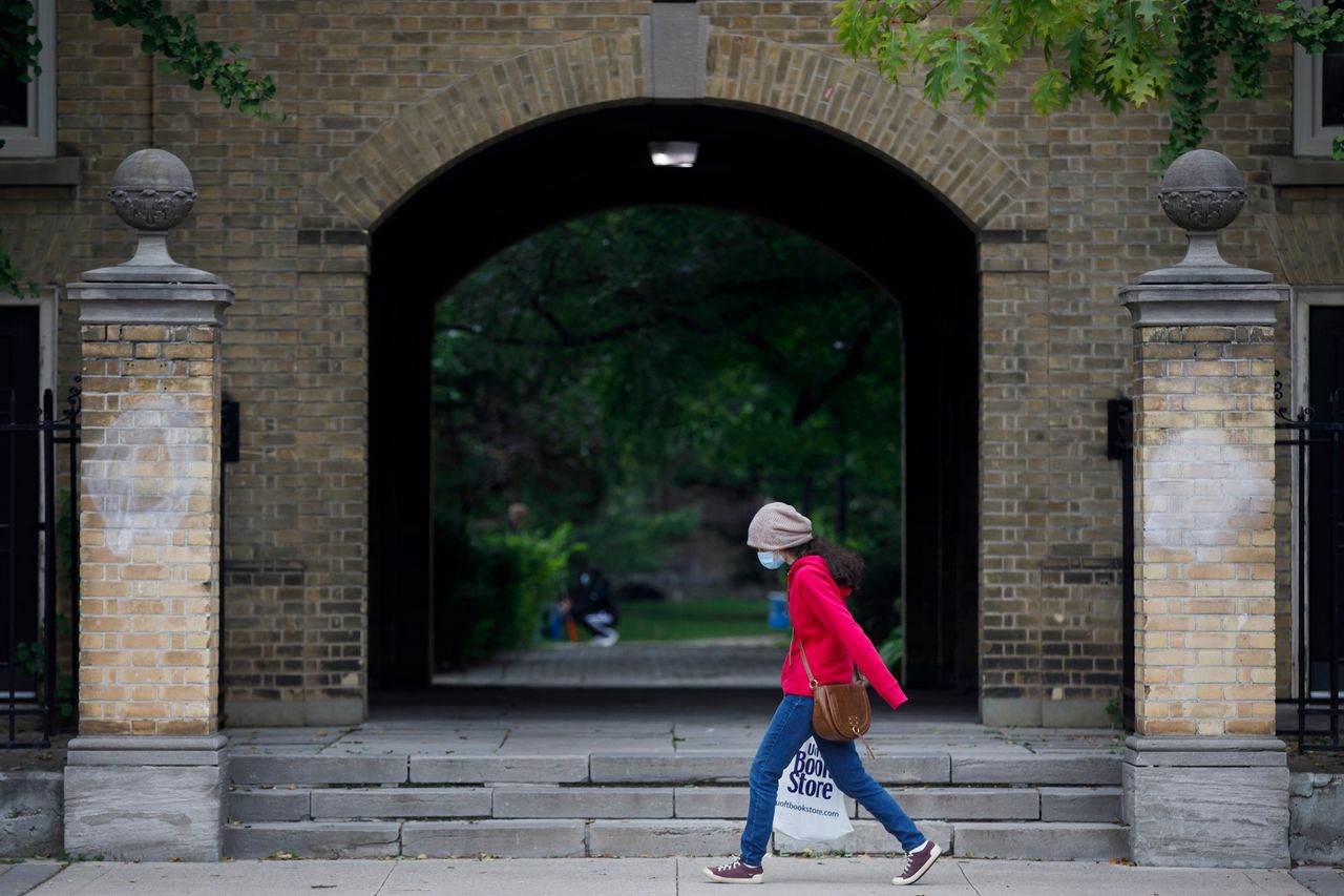 A person carrying a University of Toronto book store shopping bag walks on the university's campus in Toronto on Sept. 8, 2020.