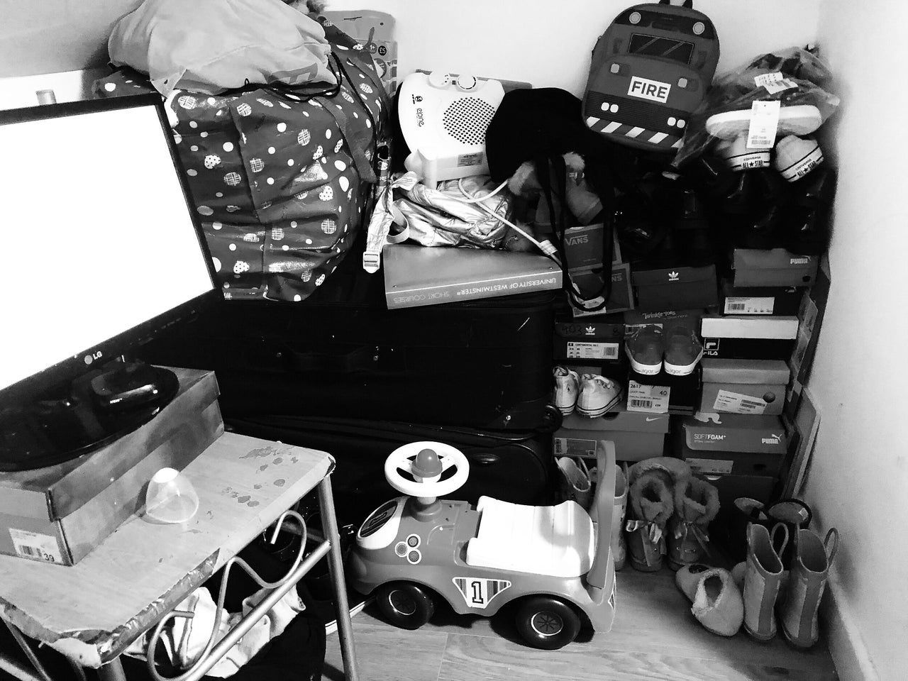 Belongings stuffed under the eaves in Rafiat's small room. The ceiling is so low, she has to sit on the floor to use her computer.