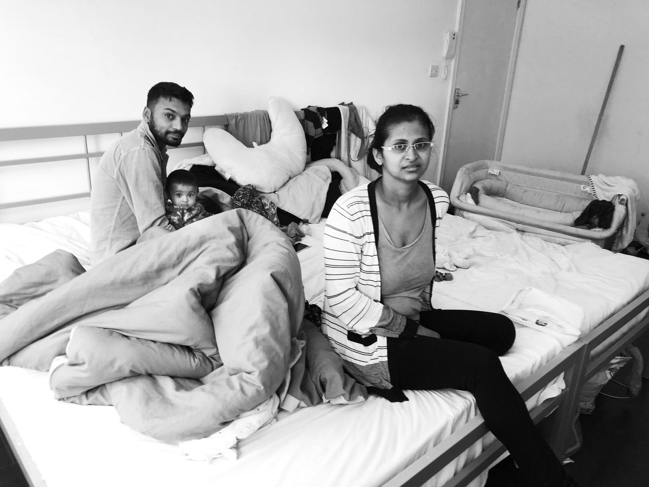 Jankhana (right) and Milan with their daughter Anaaya, on the beds in the room where they lived.