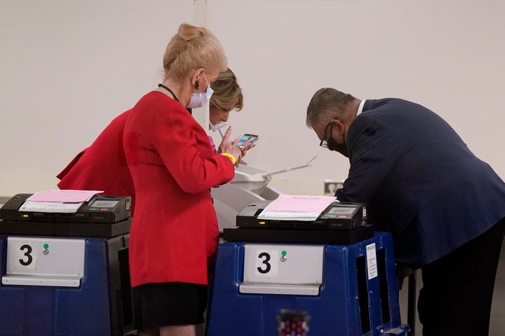 Linda Brickman, front left, vice chair of the Maricopa County Republicans, Dr. Kelli Ward, back left, chair of the Arizona Republican Party, talk with Rey Valenzuela, right, Maricopa County Elections Department Director of Early Voting and Election Services, as the department conducts a post-election logic and accuracy test for the general election Wednesday, Nov. 18, 2020, in Phoenix. (AP Photo/Ross D. Franklin)