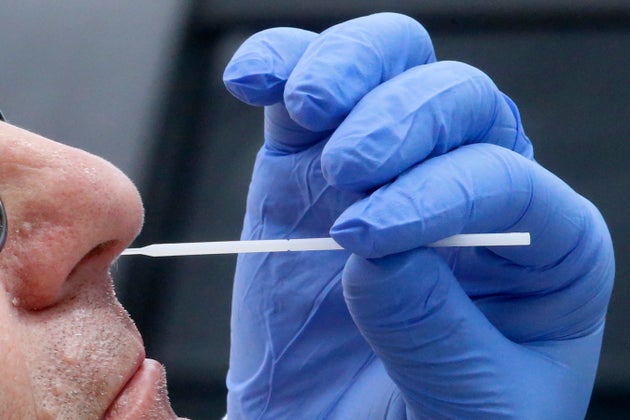 A nurse uses a swab to perform a coronavirus test in Salt Lake City. The FBI in New Jersey is asking...