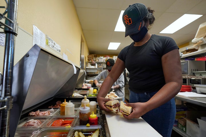 Lakshmi Davulur prepares a sandwich for a lunch patron at the San Francisco Deli in Redding, Calif., on Dec. 3, 2020. Brenda Luntey, who owns the deli with her husband, is openly violating the state's order to close her restaurant to indoor dining. She takes all the precautions advised, but doesn't force customers to wear a face mask.