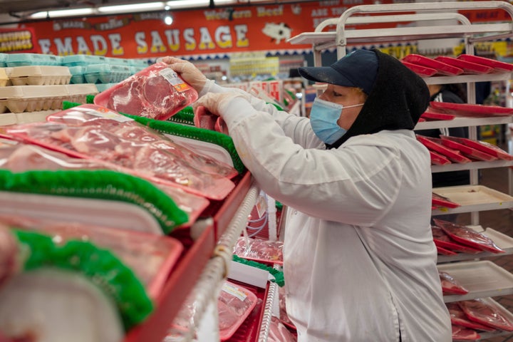 Essential workers such as this grocery store employee are likely to be prioritized for COVID-19 vaccines, but states will have to set their priorities.