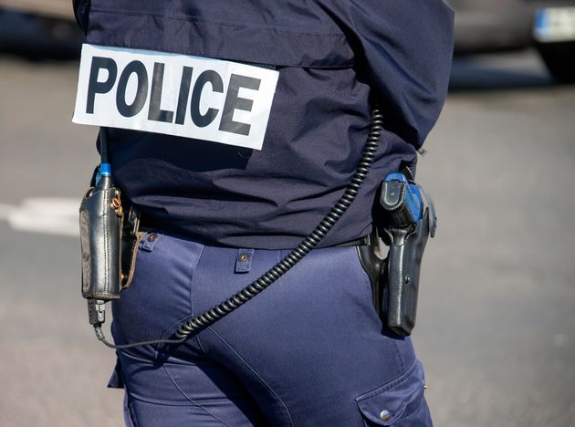 Image d'illustration d'un policier de dos avec le sigle 