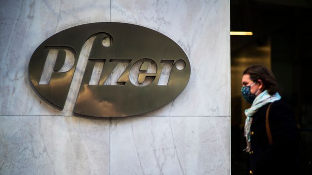 A woman walks in front of Pfizer headquarters in New York City. 