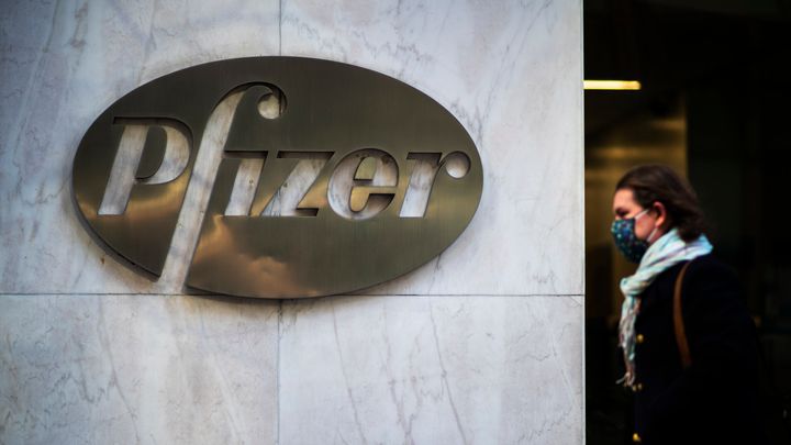 A woman walks in front of Pfizer headquarters in New York City. 