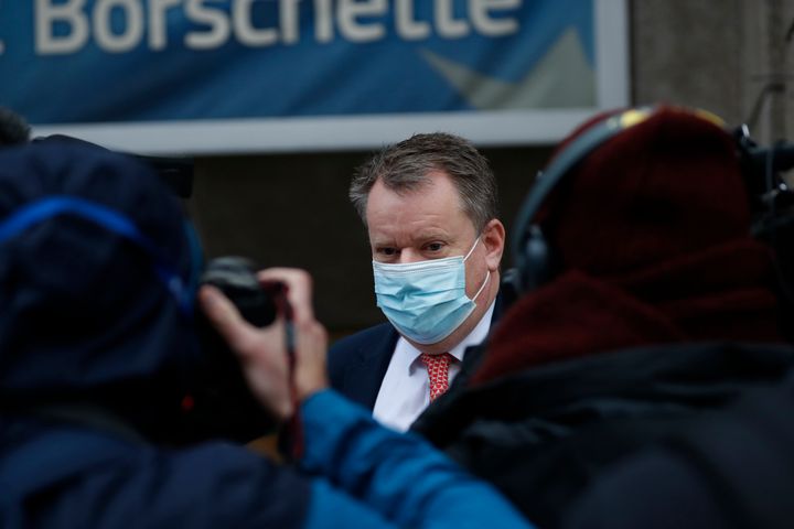 Britain's chief negotiator David Frost, centre, wears a protective face mask as he leaves the EU Borschette building after a meeting with EU chief negotiator Michel Barnier, in Brussels.