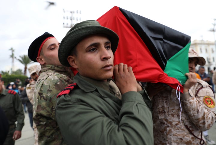 Libyan security personnel carry a coffin on Jan. 5, 2020, during the funeral of people who were killed in a UAE attack on a military academy in Tripoli.