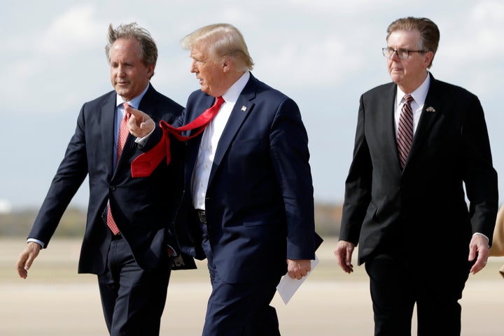 President Donald Trump walks with Texas Attorney General Ken Paxton (left) and Texas Lt. Gov. Dan Patrick (right) at Au