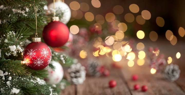 Christmas tree with red and white baubles and lights against an old wood background