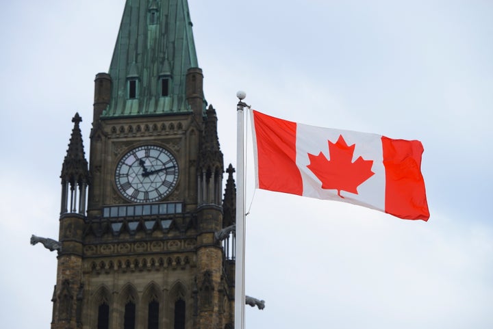 A Canadian flag flies by Parliament Hill in Ottawa on March 13, 2020.